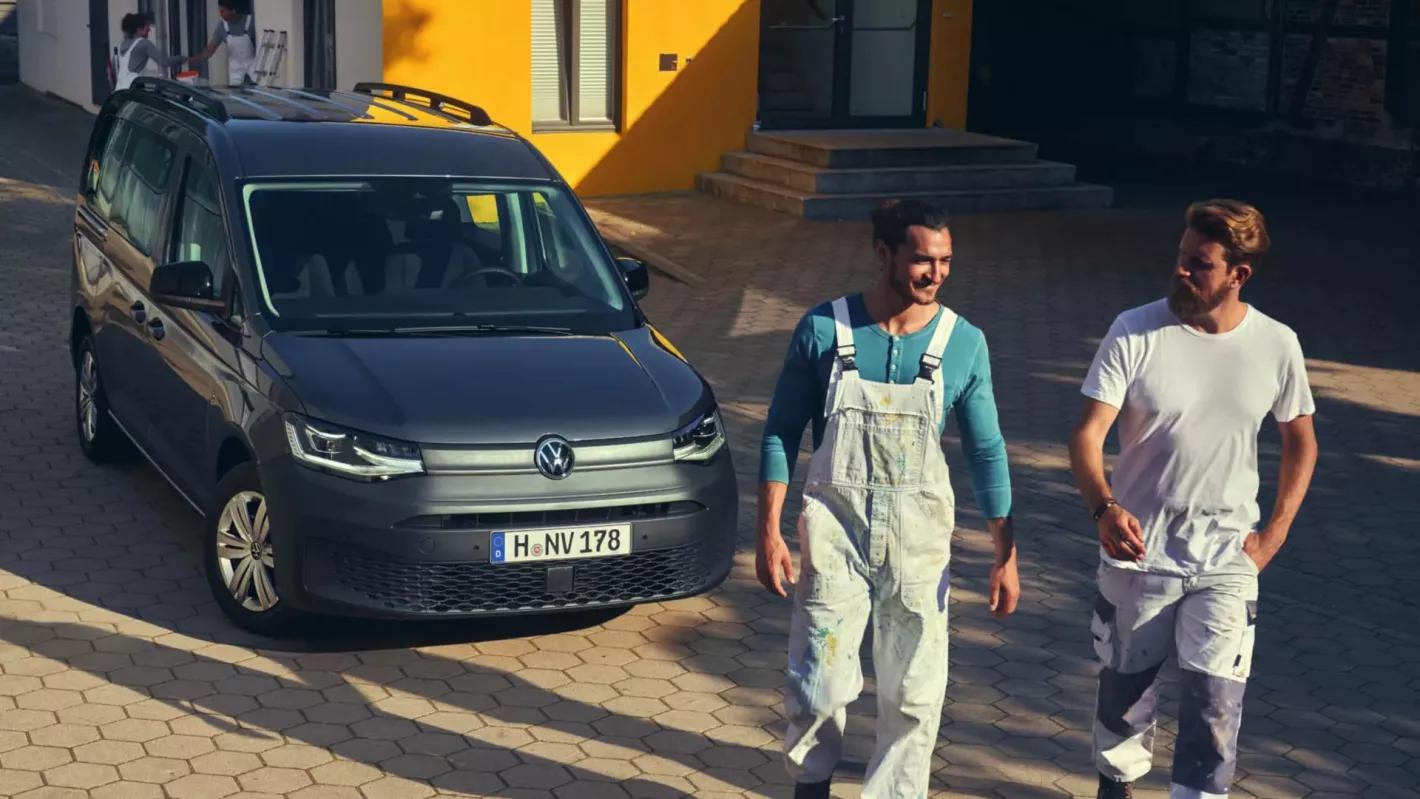 2 mannen stappen weg van een donkere caddy cargo dubbele cabine